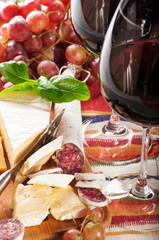 Red wine in  glass with grapes, camembert, emmentaler