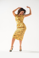 Beautiful girl in a yellow dress dancing