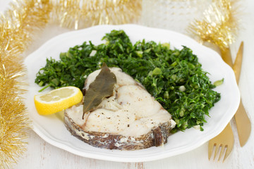 boiled fish with lemon and cabbage on white plate