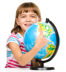 Little girl is examining globe