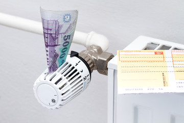 heating thermostat with money, expensive heating costs concept