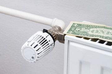 heating thermostat with money,expensive heating costs concept