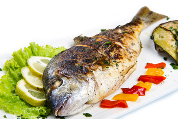 Grilled gilt head sea bream on plate with lemon ,salad and grill