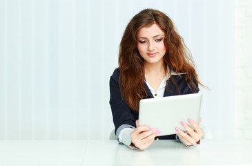 Happy young businesswoman sitting at the table 