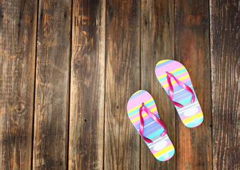 colorful flip flops on wooden deck. summer background