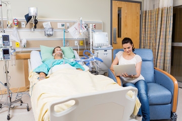 Woman With Digital Tablet Sitting By Patient