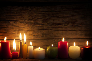 Candles in night in christmas mood on vintage wooden boards