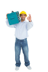 Handyman in hard hat with toolbox gesturing okay sign
