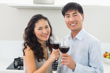 Loving young couple with wine glasses in kitchen
