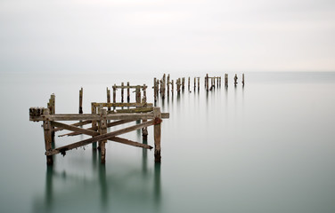 Fine art landschapsbeeld van verlaten pier in melkachtige lange blootstelling