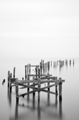 Fine art landscape image of derelict pier in milky long exposure