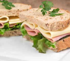 Fresh ham and cheese on white sandwich in rustic kitchen setting