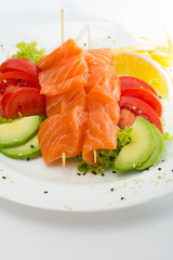 raw salmon fillet on sticks with vegetables