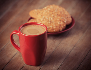 Cookies and cup of coffee with christmas gifts at background