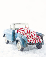 Blue toy truck carrying striped peppermint candy © Anna-Mari West