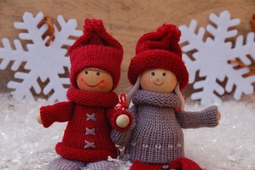 Puppenkinder auf Holz mit Schneeflocken