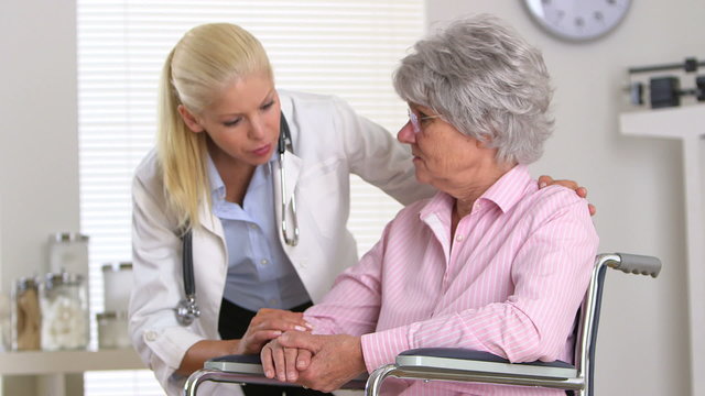 female doctor talking to patient in wheelchair