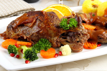 Baked wild rabbit meat with potato dumplings and vegetables