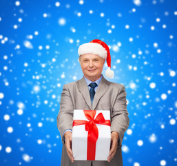 smiling man in suit and santa helper hat with gift