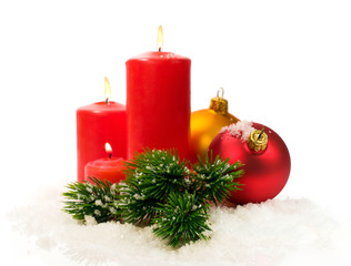 red candles and fir branches and Christmas balls in snow