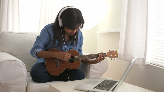 Black girl singing and playing ukulele