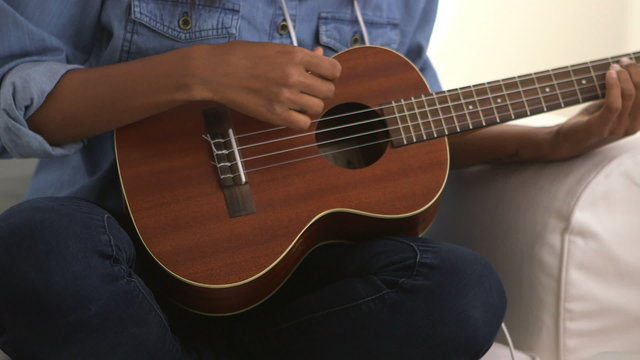Close up of girl strumming ukulele