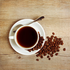 Coffee cup and coffee beans on wooden table
