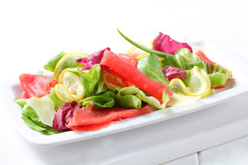 Lettuce with thin slices of lemon and raw beef