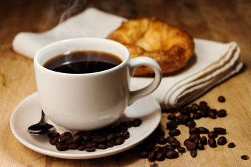coffee,croissant and coffee bean on wooden table