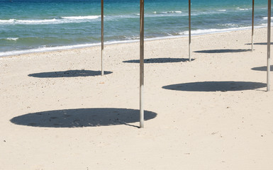 Shades of parasols on sea beach in sunny day