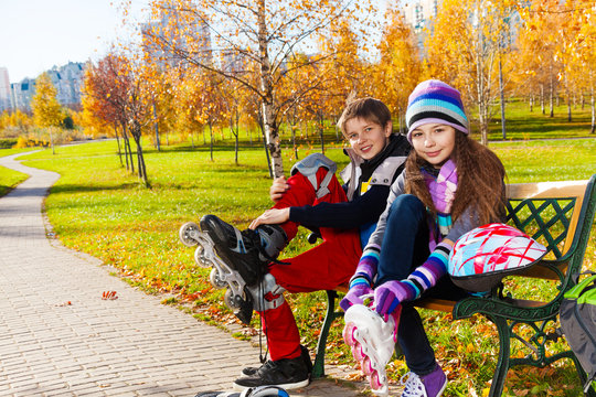 Two Kids Putting On Roller Blades