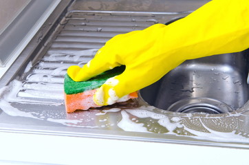 Person   cleaning the kitchen sink with a glove