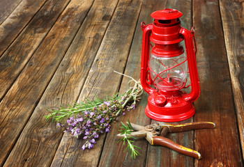 red vintage kerosene lamp, and sage flowers on wooden table