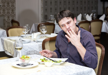 Fototapeta na wymiar young man having dinner in a restaurant