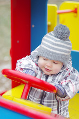 Fototapeta na wymiar baby age 1 year driving car on playground