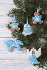 Gingerbread figures on the Christmas tree on a wooden background