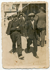 CIRCA 1930: Two young men walking around town