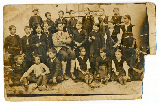 CIRCA 1930: Classmates with teacher