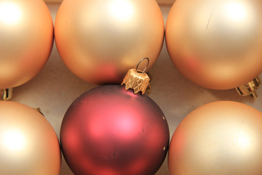 Red Ornament On A Pile Of Golden Ornaments