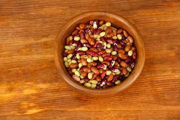Wooden bowl with beans on wooden background