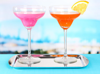 Glasses of cocktails on table near pool