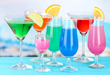 Glasses of cocktails on table near pool
