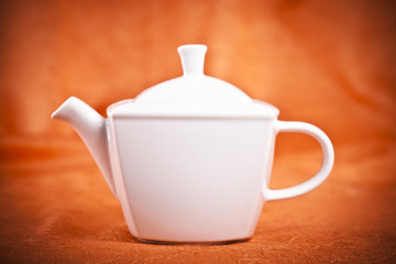 teapot isolated on orange fabric  background