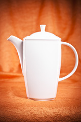 teapot isolated on orange fabric  background