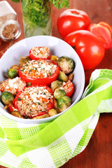 Stuffed tomatoes in bowl on wooden table close-up
