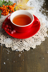 Still life with  orange viburnum  tea in cup, berries and snow,