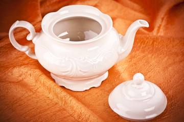 teapot isolated on orange fabric  background