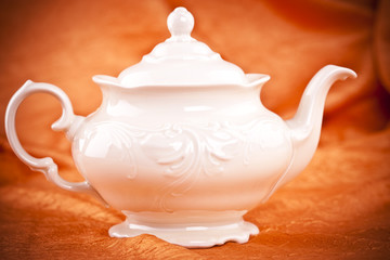 teapot isolated on orange fabric  background
