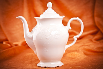 teapot isolated on orange fabric  background