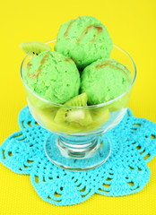 Delicious ice cream on glass vase on yellow tablecloth